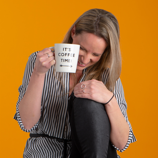 Photo fo Julia Morgan laughing while holding coffee cup