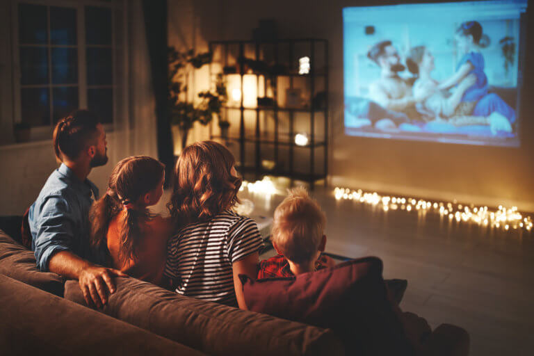 Family watching a projector of home videos