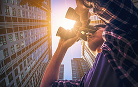 Man looking through binoculars with sun shining