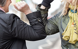 Women greeting in the street by touching elbows