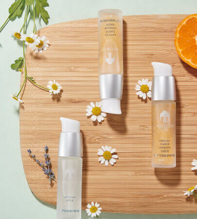 nu skin products arranged on tray with flowers and orange slice