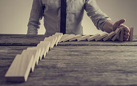 Falling dominoes being stopped by man