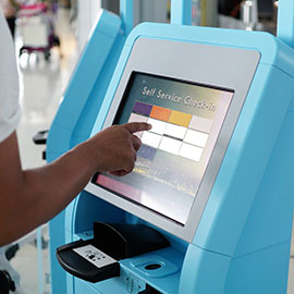 Person buying plane ticket at self-serve kiosk