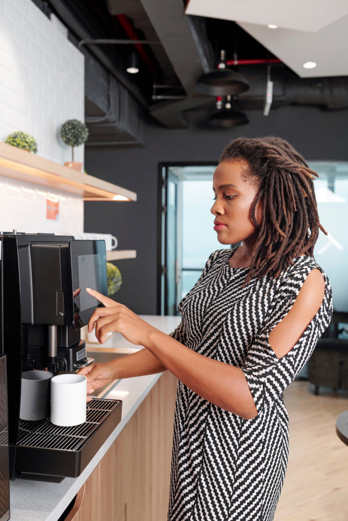 Business woman pouring herself coffee