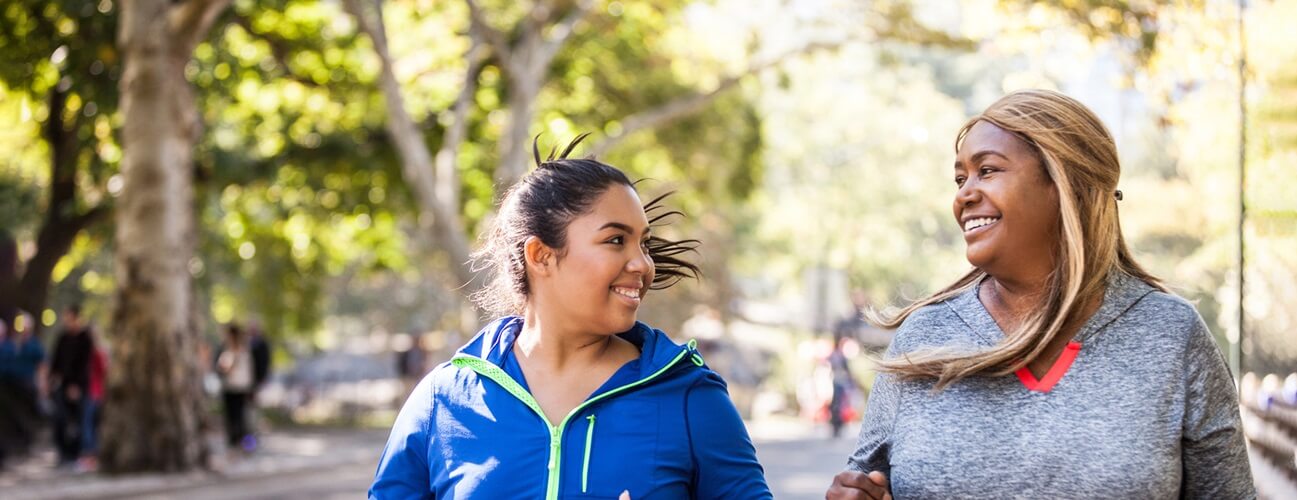 Two women smiling and jogging