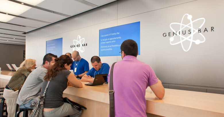 Apple Genius Bar with employees teaching customers how to use products
