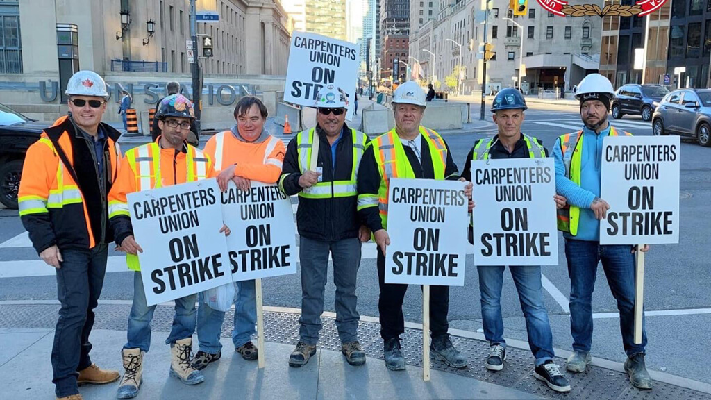 Transit workers strike Downtown Toronto holding signs